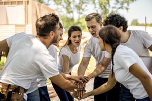 An image of a group of people excited to start building a house 